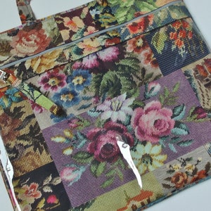 Pode incluir: Uma bolsa tote com padr&atilde;o floral e um painel frontal de pl&aacute;stico transparente. A bolsa tem fecho de correr e uma al&ccedil;a destac&aacute;vel. O padr&atilde;o floral &eacute; um patchwork de diferentes desenhos florais.