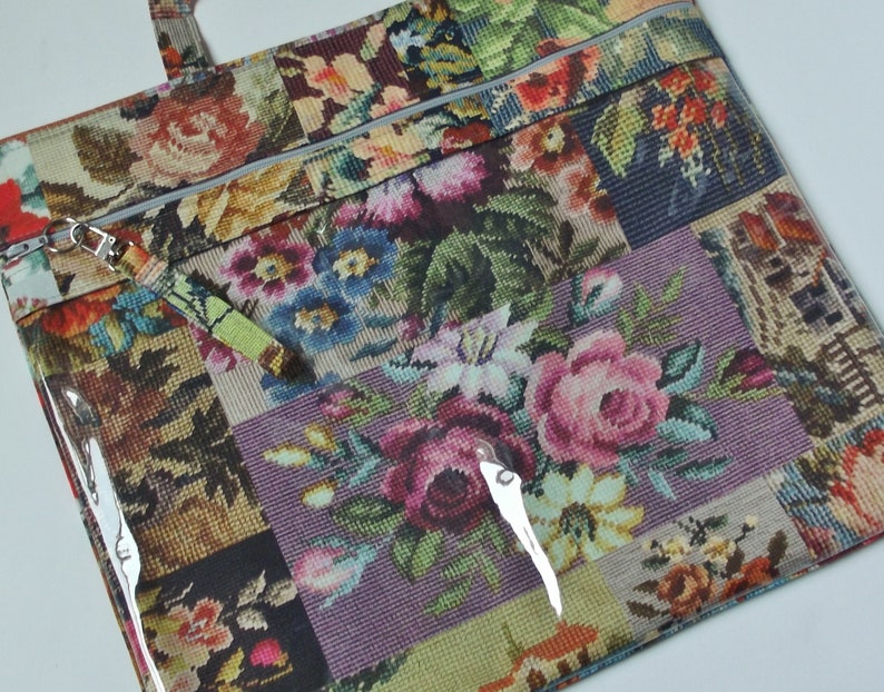 Pode incluir: Uma bolsa tote com padr&atilde;o floral e um painel frontal de pl&aacute;stico transparente. A bolsa tem fecho de correr e uma al&ccedil;a destac&aacute;vel. O padr&atilde;o floral &eacute; um patchwork de diferentes desenhos florais.