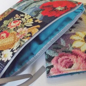 Pode incluir: Duas bolsas de tecido com padr&atilde;o floral e fecho de correr. A bolsa maior tem um forro azul e uma fita cinzenta. A bolsa menor tem um fecho de bot&atilde;o e um bot&atilde;o prateado.