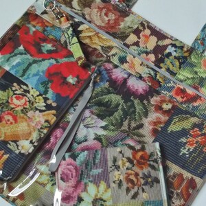 Pode incluir: Uma bolsa tote com padr&atilde;o floral com duas pequenas bolsas com z&iacute;per. A bolsa tote tem uma frente de pl&aacute;stico transparente e um forro de tecido com padr&atilde;o floral. As bolsas tamb&eacute;m t&ecirc;m padr&atilde;o floral e fechos de z&iacute;per.