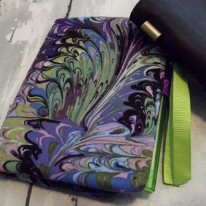 May include: A purple, green, and black marbled fabric notebook cover with a lime green ribbon.