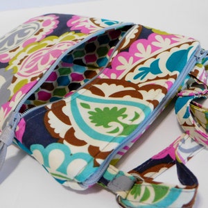 K&ouml;nnte beinhalten: Eine bunte Umh&auml;ngetasche mit Paisley-Muster, Rei&szlig;verschluss und verstellbarem grauen Schultergurt.