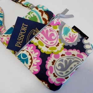 K&ouml;nnte beinhalten: Eine kleine Umh&auml;ngetasche mit Paisley-Muster und Rei&szlig;verschluss. Die Tasche hat einen blauen Reisepass in der Rei&szlig;verschlusstasche. Die Tasche hat einen silbernen Rei&szlig;verschluss und einen silbernen Riemen.