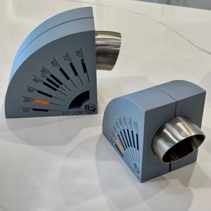 May include: Two gray plastic pipe angle finders with a silver metal pipe insert. The finders have a protractor with markings from 10 to 80 degrees and the text "2.5 - 150" and "55".