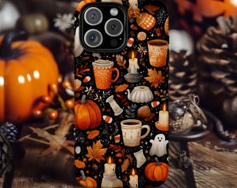 Könnte beinhalten: Schwarze Handyhülle mit herbstlichem Muster. Das Design zeigt Kürbisse, Blätter, Kerzen, Tassen und einen Geist auf schwarzem Hintergrund. Die Hülle hat eine Kameraaussparung und liegt auf einer Holzoberfläche.