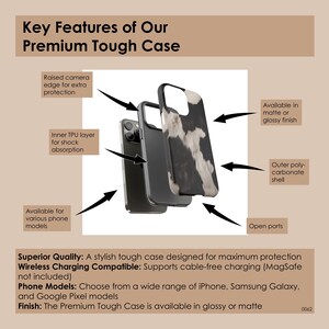 May include: A black and white cow print phone case with a black outer shell. The case has raised edges for camera protection and an inner TPU layer for shock absorption. It is wireless charging compatible and available in matte or glossy finishes.