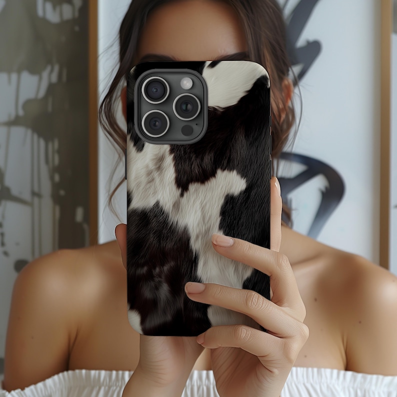 Cowhide phone cover with black and white animal pattern in stylish cow style art. Unique and trendy phone case offers protection as a tough case for iPhone 16, iPhone 15, iPhone 14, iPhone 13, iPhone Pro Max, Samsung Galaxy S23 S24 S25 Ultra, and Google Pixel 8 9 Pro. A perfect gift for her, this eye-catching phone cover combines fashion and function with durable protection and a bold western-inspired design.