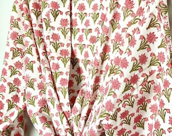 May include: A white cotton robe with a pink floral print. The robe has a tie closure and long sleeves.