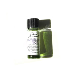Pode incluir: Um pequeno frasco de vidro com uma tampa preta cheio de um líquido verde. O rótulo diz "LAVENDE NOIR" e "BOTANICAL PERFUME".