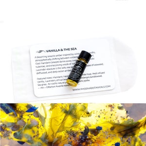 Pode incluir: Um pequeno frasco de vidro com l&iacute;quido &acirc;mbar e um r&oacute;tulo preto que diz "Vanilla & The Sea" e "Phoenix Botanicals". O frasco est&aacute; sobre um cart&atilde;o branco com texto sobre o produto.