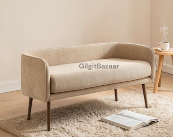 Banco tapizado de respaldo bajo, asiento auxiliar con estructura metálica, color beige, estilo contemporáneo.