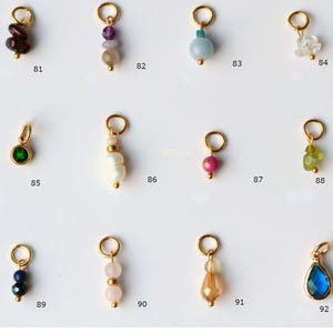May include: A selection of gold-coloured gemstone pendants, each with a unique design and colour. The pendants are numbered 81 to 92. The text "Geburtssteine" is at the top of the image.