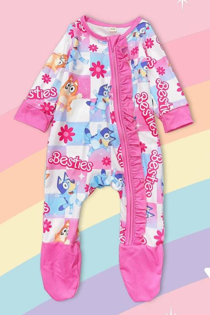 Może przedstawiać: R&oacute;żowo-biały pajacyk dla dziecka z postaciami z kresk&oacute;wek i napisem "Besties". Pajacyk ma zamek błyskawiczny z przodu, r&oacute;żowe falbanki i zakryte stopy. Wz&oacute;r zawiera postacie z kresk&oacute;wek, kwiaty i wz&oacute;r w szachownicę.