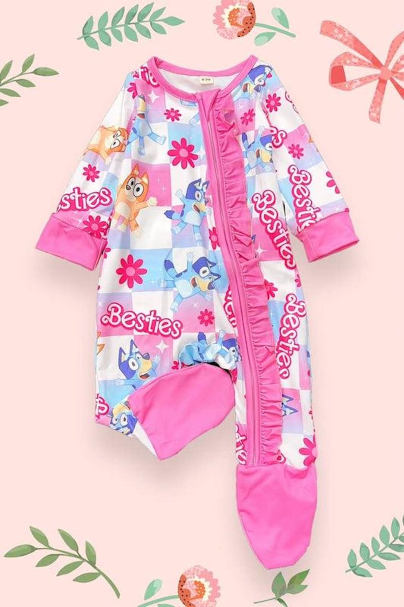 Może przedstawiać: R&oacute;żowo-białe śpioszki dla dziecka z postaciami z kresk&oacute;wek, kwiatami i napisem "Besties". Śpioszki mają zamek błyskawiczny, r&oacute;żowe wykończenia i dołączone stopy. Wz&oacute;r zawiera wz&oacute;r w szachownicę.