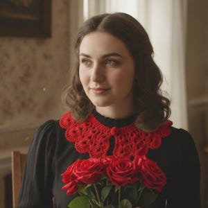 Può includere: Una persona indossa un vestito nero con un colletto rosso all'uncinetto, che tiene in mano un mazzo di rose rosse. Le rose sono in piena fioritura. Lo sfondo presenta una carta da parati floreale e una sedia di legno.