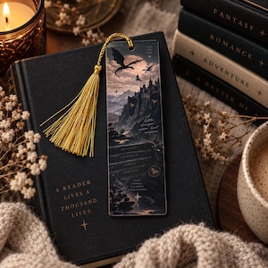 May include: A rectangular bookmark featuring a dark fantasy illustration of a castle on a mountain under a full moon with flying dragons. The bookmark includes a gold tassel and text including "Knowledge is Power" and "Some things are worth everything."