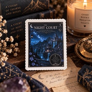 May include: A rectangular sticker with scalloped edges featuring a dark blue night scene of a castle on a cliff with waterfalls and a starry sky. The text reads The Night Court, To the stars who listen, and the dreams that are answered, and Home of shadows and starlight, power and promise.