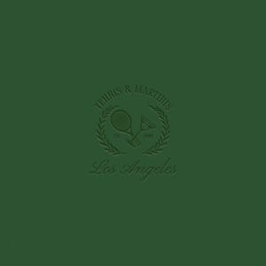 Op de afbeelding: Een groen logo met de tekst "Tennis & Martius" in een cirkel met een laurierkransontwerp. De tekst "Est. 2010" staat onder de krans. Twee gekruiste tennisrackets bevinden zich in de krans. De tekst "Los Angeles" staat onder de krans.