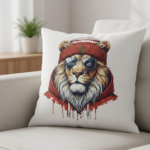 Peut inclure: Un coussin décoratif avec un lion portant un bonnet rouge, des lunettes de soleil et un sweat à capuche rouge. Le lion a une longue barbe blanche et un design de style aquarelle avec des gouttes rouges.