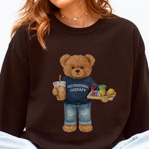 May include: A set of three ceramic mugs with a speckled, matte finish. Each mug features a different color: light blue, cream, and gray. The mugs have a simple, modern design with a rounded shape and a comfortable handle.