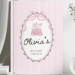 May include: A hardcover notebook with a light pink and white vertical striped cover. The center features an oval frame with a pink ribbon, a typewriter illustration, and the text Olivia's NOTES FROM CHAPTER 13 in dark brown lettering.