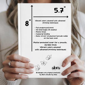 Puede incluir: Un cuaderno blanco con acabado mate, de 20,3 cm por 14,5 cm, sostenido por una persona. El cuaderno presenta un dise&ntilde;o de mariposa y el texto &laquo;Colores vibrantes logrados con t&eacute;cnicas de impresi&oacute;n avanzadas&raquo;. El cuaderno tiene 150 p&aacute;ginas rayadas.