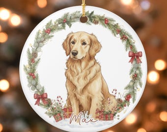 May include: A round, white Christmas ornament featuring a Golden Retriever dog illustration. The dog is surrounded by a festive wreath of greenery, red berries, and bows. The name "Max" is written below the dog.