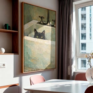 May include: A framed painting of a black cat in a bathtub, with a vintage aesthetic. The artwork uses a green and white colour palette. The painting is mounted on a light-coloured wall in a room with a window and a table.