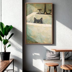 May include: A framed art print depicting a black cat in a bathtub. The artwork uses a muted colour palette of greens and beiges, giving it a vintage feel. The cat's yellow eyes are visible. The frame is a light brown colour. The image is a painting.