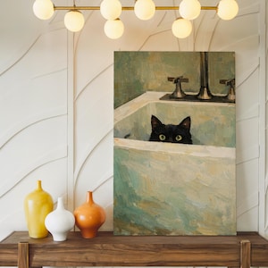 May include: An oil painting shows a black cat looking over the edge of a white sink. The painting has a green and white colour scheme. A wooden shelf below the painting holds three decorative vases in yellow, white, and orange.