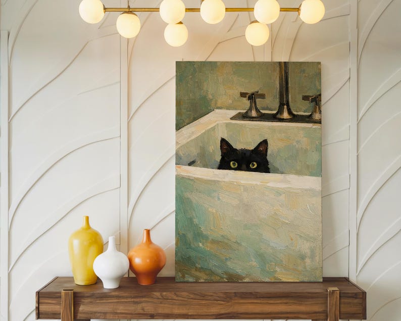 May include: An oil painting shows a black cat looking over the edge of a white sink. The painting has a green and white colour scheme. A wooden shelf below the painting holds three decorative vases in yellow, white, and orange.