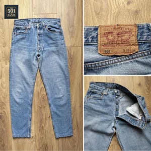 Op de afbeelding: Lichtblauwe denim jeans met een knoopsluiting. De jeans hebben een klassiek ontwerp met vijf zakken en een leren patch met het Levi Strauss & Co. logo. De taille is 73,66 cm en de binnenbeenlengte is 86,36 cm.