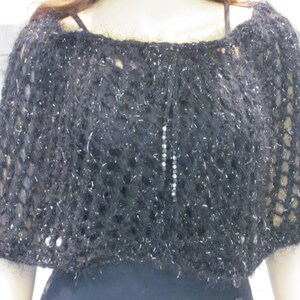 May include: Black knitted shawl with a sparkly thread and a silver chain detail.