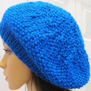 May include: A bright blue knitted beanie hat. The hat is made of a soft, textured yarn and has a simple, classic design.