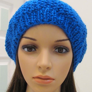 May include: A bright blue knitted beanie hat. The hat is made of a soft, textured yarn and has a simple, classic design.