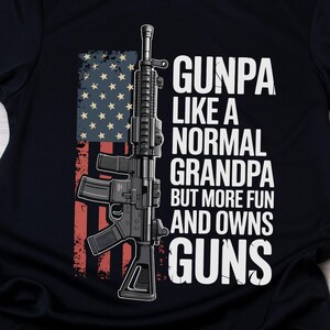 May include: Black t-shirt featuring a graphic of a rifle superimposed over a distressed American flag. The shirt displays the text "GUNPA like a normal grandpa but more fun and owns guns" in white lettering.