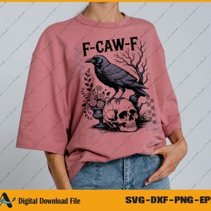 May include: Dusty rose-colored t-shirt with the text "F-CAW-F" above a graphic of a raven perched on a skull. The raven is black, and the skull is white. The shirt is a digital download file.