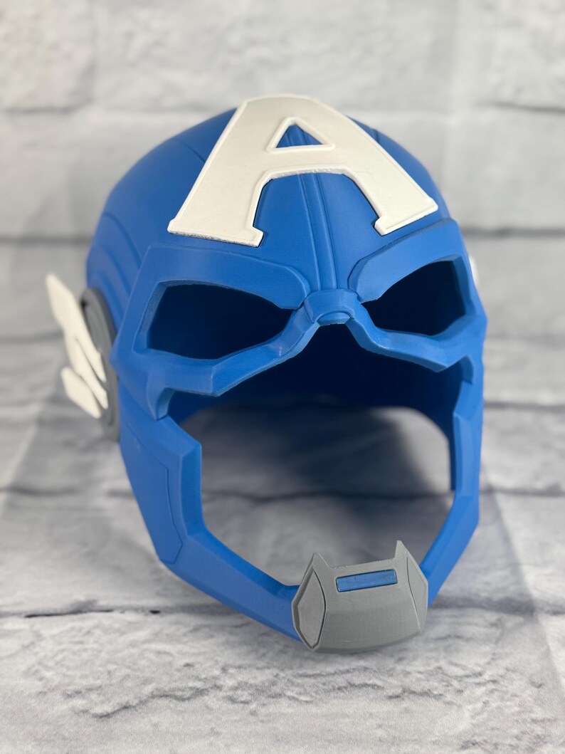 May include: Blue plastic Captain America helmet with a white "A" on the front. The helmet has a gray chin guard and eye holes.