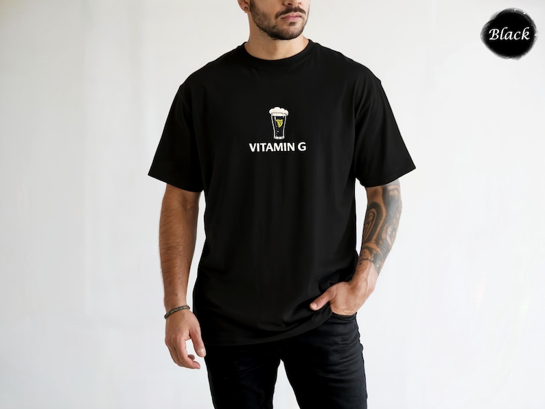 May include: Black t-shirt with a graphic of a pint of beer and the words "VITAMIN G" in white. The shirt is a classic crew neck style.