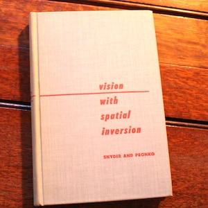 May include: A hardcover book with a light beige fabric cover. The front cover features red text that reads vision with spatial inversion and the authors Snyder and Pronko. A thin horizontal red line separates the title from the subtitle.
