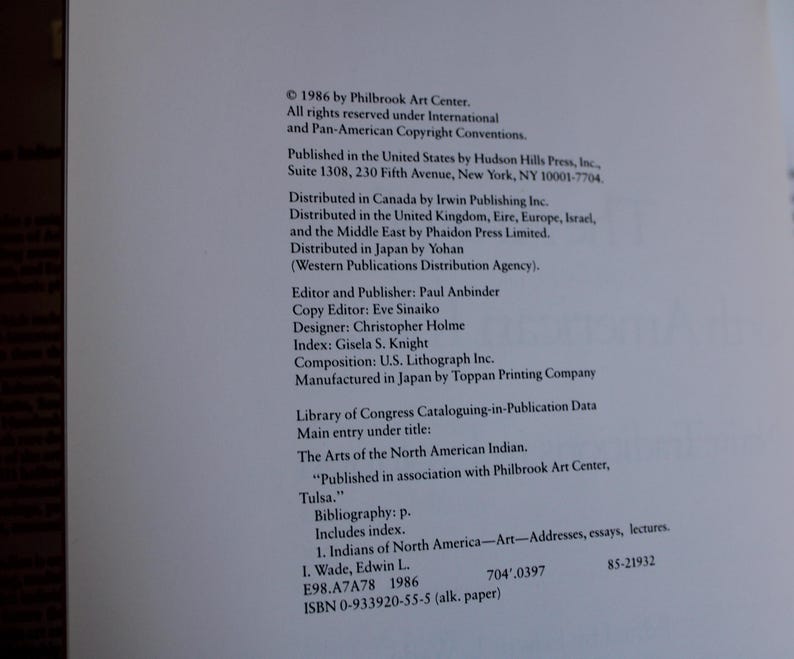 以下が含まれることがあります： 「The Arts of the North American Indian」というタイトルと「Published in association with Philbrook Art Center, Tulsa.」というテキストが書かれた本の表紙。表紙は白で、テキストは黒です。