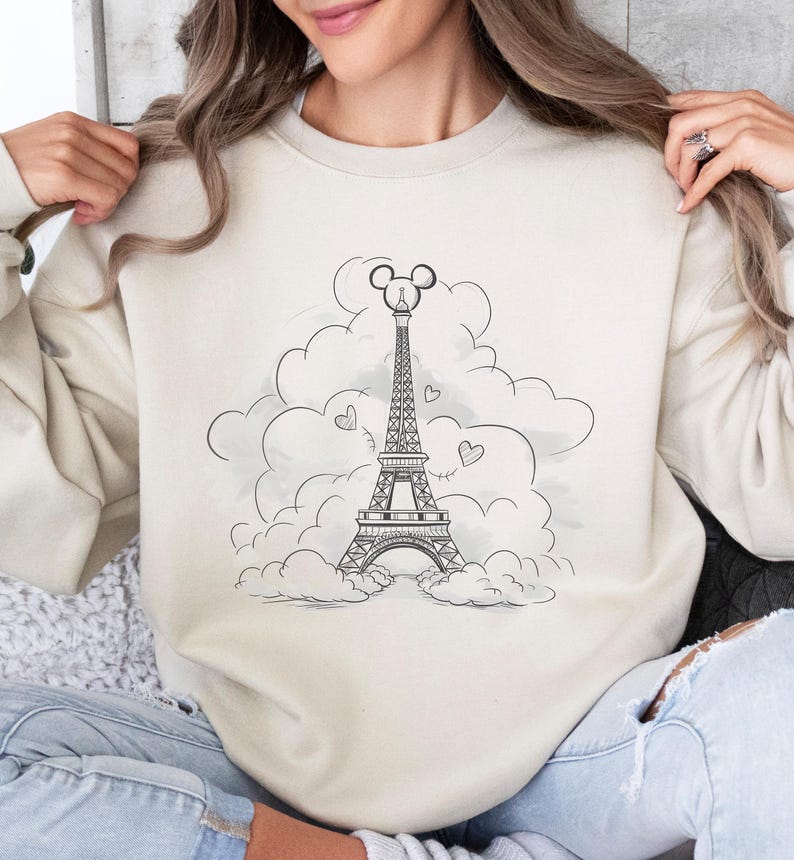 Disney meets Paris in this magical tee featuring the Eiffel Tower with a classic Mickey Mouse head perched on top. Perfect for Disneyland Paris vacations, this design blends iconic French landmarks with beloved Disney charm. Ideal for families, travel lovers, or Disney fans making memories in the City of Light. A stylish and fun shirt for park visits, photo ops, or post-trip souvenirs.