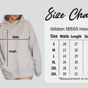 Puede incluir: Una sudadera con capucha Gildan 18500 gris claro con una tabla de tallas. La tabla muestra medidas en pulgadas para el ancho, largo y largo de manga, desde la talla S hasta la 3XL. La sudadera tiene capucha y bolsillo delantero.