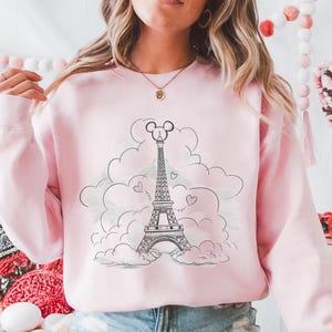 Disney meets Paris in this magical tee featuring the Eiffel Tower with a classic Mickey Mouse head perched on top. Perfect for Disneyland Paris vacations, this design blends iconic French landmarks with beloved Disney charm. Ideal for families, travel lovers, or Disney fans making memories in the City of Light. A stylish and fun shirt for park visits, photo ops, or post-trip souvenirs.