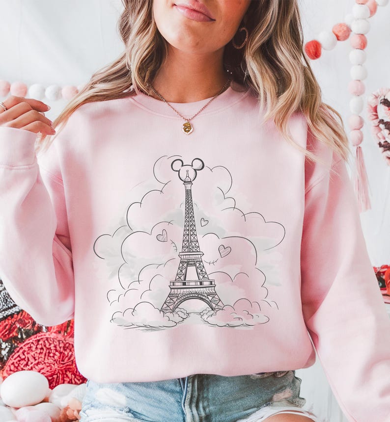Disney meets Paris in this magical tee featuring the Eiffel Tower with a classic Mickey Mouse head perched on top. Perfect for Disneyland Paris vacations, this design blends iconic French landmarks with beloved Disney charm. Ideal for families, travel lovers, or Disney fans making memories in the City of Light. A stylish and fun shirt for park visits, photo ops, or post-trip souvenirs.