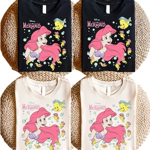 Retro-style Disney Little Mermaid shirt featuring Princess Ariel, perfect for girls’ trips, family vacations, or matching outfits at Walt Disney World. This playful tee or hoodie showcases nostalgic design elements with seashells, waves, and classic Ariel artwork. Great for park days, Disney cruise wear, or fans of the original Disney princess with a love for under-the-sea adventure and magical memories.
