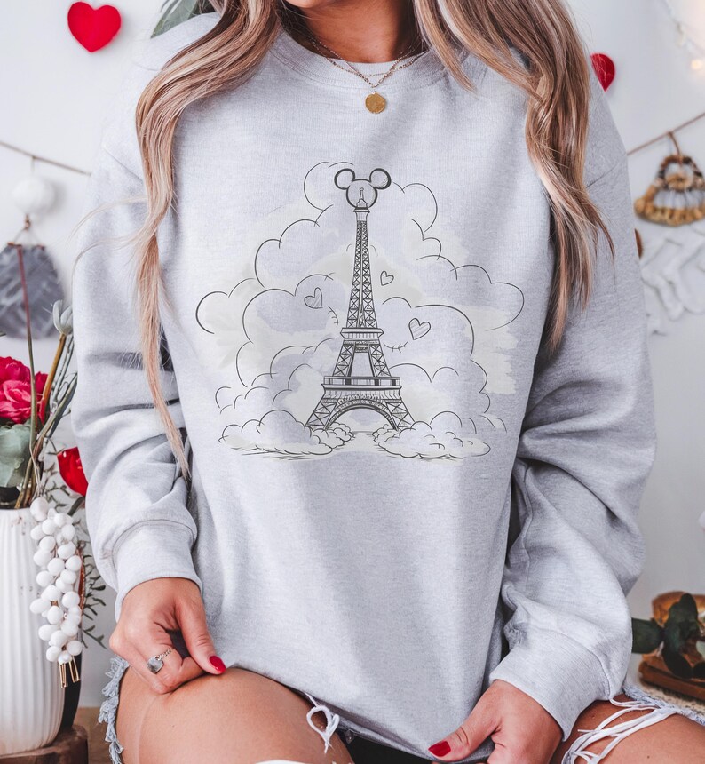 Disney meets Paris in this magical tee featuring the Eiffel Tower with a classic Mickey Mouse head perched on top. Perfect for Disneyland Paris vacations, this design blends iconic French landmarks with beloved Disney charm. Ideal for families, travel lovers, or Disney fans making memories in the City of Light. A stylish and fun shirt for park visits, photo ops, or post-trip souvenirs.