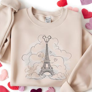 Disney meets Paris in this magical tee featuring the Eiffel Tower with a classic Mickey Mouse head perched on top. Perfect for Disneyland Paris vacations, this design blends iconic French landmarks with beloved Disney charm. Ideal for families, travel lovers, or Disney fans making memories in the City of Light. A stylish and fun shirt for park visits, photo ops, or post-trip souvenirs.