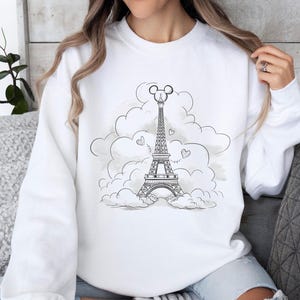 Disney meets Paris in this magical tee featuring the Eiffel Tower with a classic Mickey Mouse head perched on top. Perfect for Disneyland Paris vacations, this design blends iconic French landmarks with beloved Disney charm. Ideal for families, travel lovers, or Disney fans making memories in the City of Light. A stylish and fun shirt for park visits, photo ops, or post-trip souvenirs.