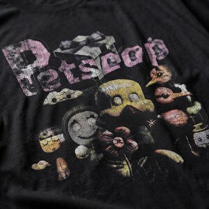 Close-up of the distressed graphic print and heavy cotton texture on the black t-shirt.